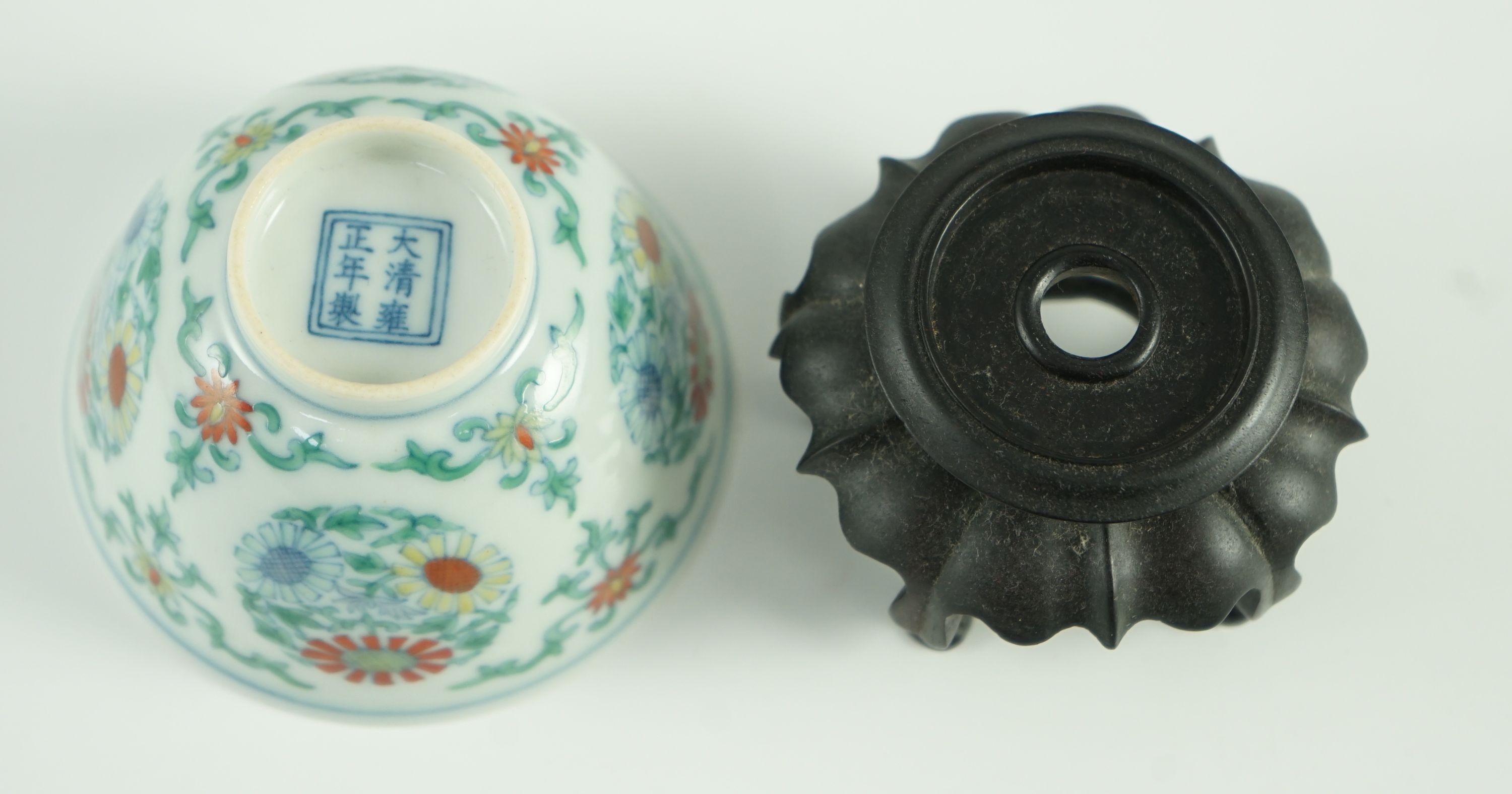 A Chinese doucai ‘chrysanthemum medallion’ cup, Yongzheng mark, probably late 19th/early 20th century, 7.2cm diameter, wood stand
